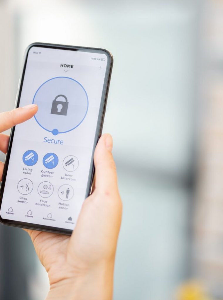 Female closes the door or turns on the house alarm with phone Female closes the door or turns on the house alarm with phone